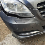 Grey car with cracked headlight and front bumper